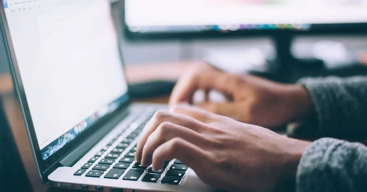 Person typing on a laptop at a wooden desk, used for creating a first Shopify account

---

# content