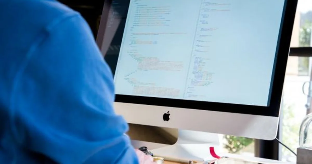 Developer working with code on a desktop display