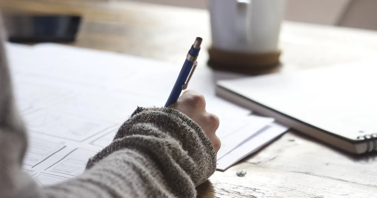 Notebook with search phrases next to product samples, standing in for Shopify keyword research